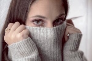 A pretty woman pulling her turtleneck sweater up to her eyes as if she's hiding. You Are Awesome.
