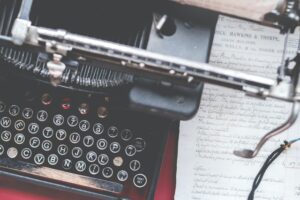 An old typewriter with a handwritten page in the background. How to Become a Better Writer