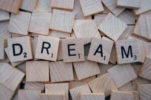 Five wood Scrabble pieces spelling the word DREAM. How to Become a Better Writer