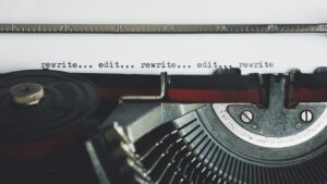 An old typewriter with working ribbon with a page stating, "rewrite. edit. rewrite. edit. rewrite." How to Become a Better Writer